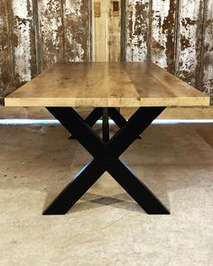 a wooden table with two black x legs