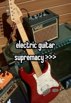 an electric guitar sitting on top of a table next to amps and other musical equipment