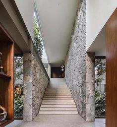 the stairs lead up to the second floor in this modern house with stone and wood accents