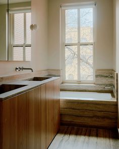 a bathroom with a sink, tub and large window