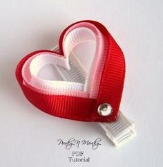 a red and white heart shaped ribbon with a clip