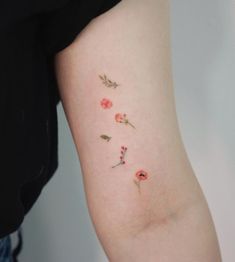 a woman's arm with flowers and leaves on the left side of her body