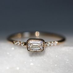 a diamond ring sitting on top of a snow covered surface with diamonds around the band