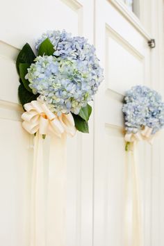 two blue and white flowers are hanging on the door