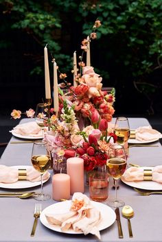 the table is set with candles, plates and napkins for dinner guests to enjoy