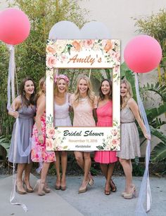 a group of women standing next to each other in front of a sign that says happily ever after