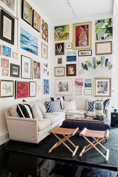 a living room filled with furniture and pictures on the wall