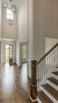 a large foyer with wood floors and white walls