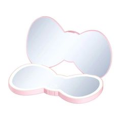 an open pink heart shaped mirror sitting on top of a table