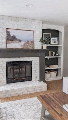 a living room with a white brick fireplace and bookcases on either side of the fire place