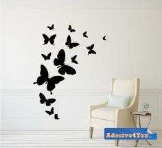 a white chair sitting next to a wall with black butterflies on it