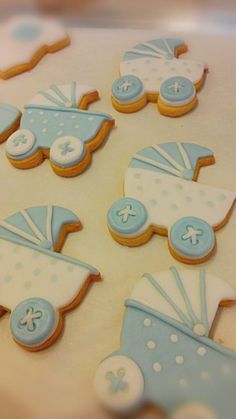 decorated cookies with blue and white designs on a table next to baby carriages,