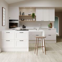 a kitchen with white cabinets and counter tops