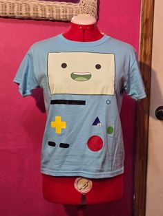 A custom made t-shirt of BMO from Adventure Time. Sizing is in US adult letter from Small to 2XL Adventure Time Clothes, Adventure Time Shirt, Custom Made T Shirts, White Plains, Adventure Time, Gender Neutral, Custom Made, Adult Outfits, Tops & Tees