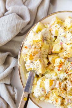 a white plate topped with potato salad next to a napkin