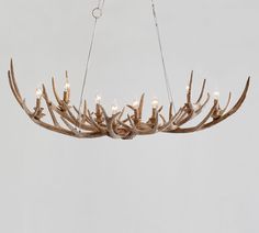 a chandelier made out of antlers with lights hanging from the middle one