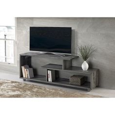 an entertainment center with a flat screen tv mounted on it's side, in front of a large window