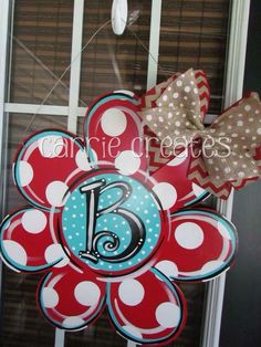 a red, white and blue door hanger with the number six on it's center