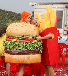 two women dressed as hamburgers and fries are posing for the camera while they both have their arms wrapped around each other