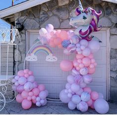 a unicorn balloon arch in front of a house