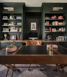 an office with built - in bookshelves, desk and leather chair is shown