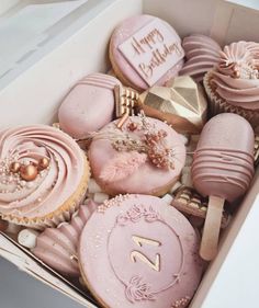 a box filled with pink and gold decorated cookies