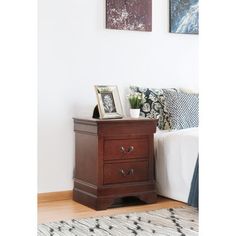 a bedroom with a bed, nightstand and pictures on the wall