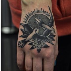 a person with a bird tattoo on their hand