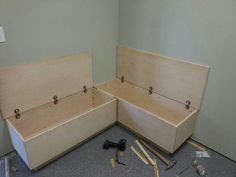 two wooden boxes sitting next to each other in a room with tools on the floor