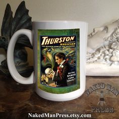 a white coffee mug sitting on top of a wooden table next to a skull statue