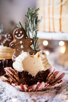 cupcakes with frosting and gingerbread decorations on top are sitting on a plate