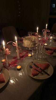 the table is set with candles, plates and napkins for a party or special occasion