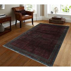 a living room filled with furniture and a rug on top of a hard wood floor