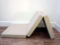 two mattresses sitting on the floor in front of a white wall