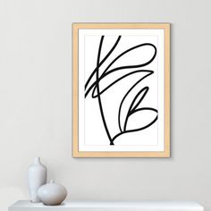 a black and white abstract painting on a wall above a shelf with a vase next to it