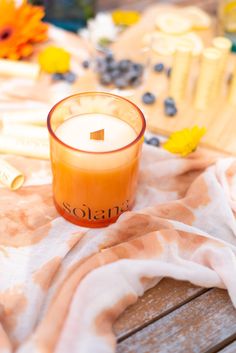 an orange candle sitting on top of a wooden table