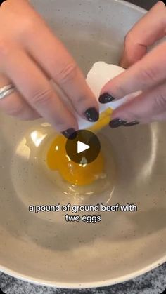 a woman is peeling an egg in a bowl