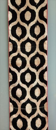 an image of a black and white rug with red trim on the bottom right corner