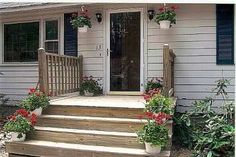 some flowers are growing on the steps in front of a house