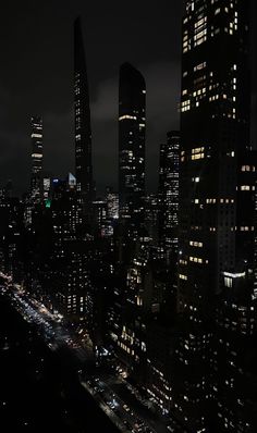 the city skyline is lit up at night, with skyscrapers in the foreground