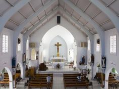 the inside of a church with pews and stained glass windows on either side of the alter