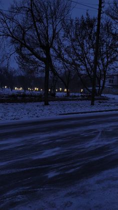 the street is covered in snow and there are no cars parked on it at night