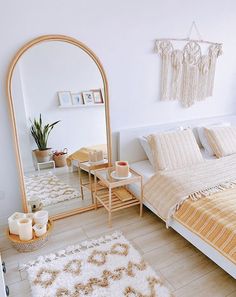 a bed room with a neatly made bed and a large mirror