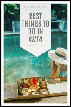 a woman sitting on the edge of a swimming pool next to a box of fruit