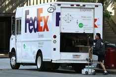 the fedex truck is parked on the side of the street