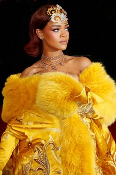 a woman in a yellow dress and fur stole with jewels on her head, wearing a tiara