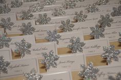 snowflake place cards are arranged in rows on a table with other place cards