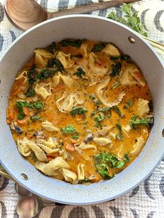 a pot filled with pasta and vegetables on top of a table