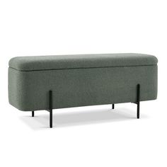 an upholstered bench with black legs and a light green fabric cover on it