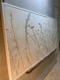 an artistically designed wall with flowers and branches on it